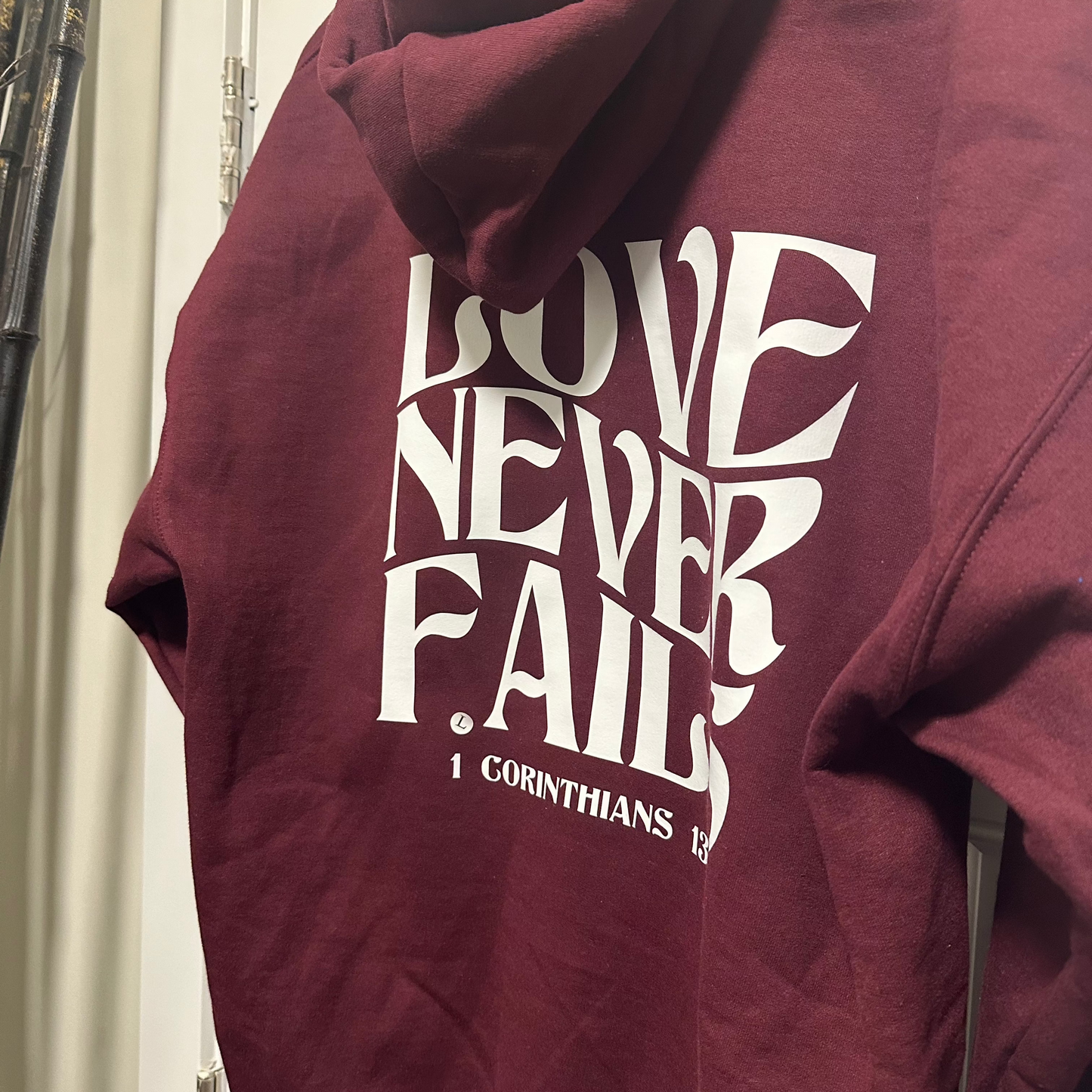 “Love Never Fails" Hooded Sweatshirt