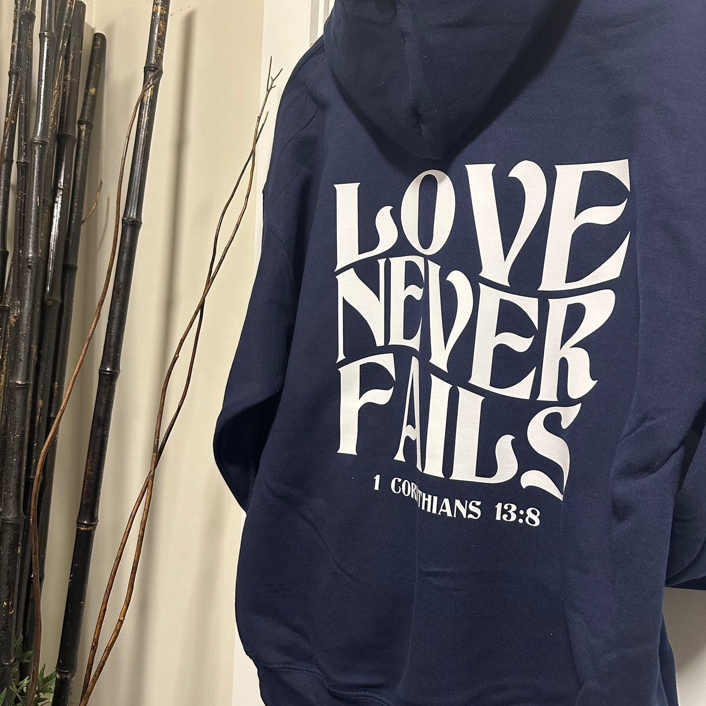 “Love Never Fails" Hooded Sweatshirt